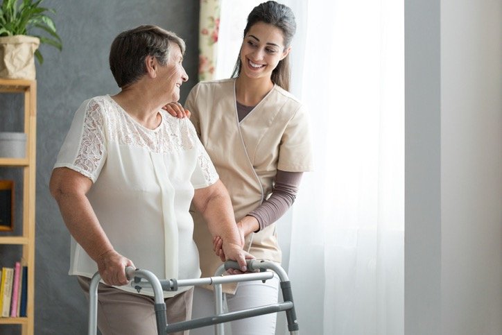 nurse helping senior to walk picture